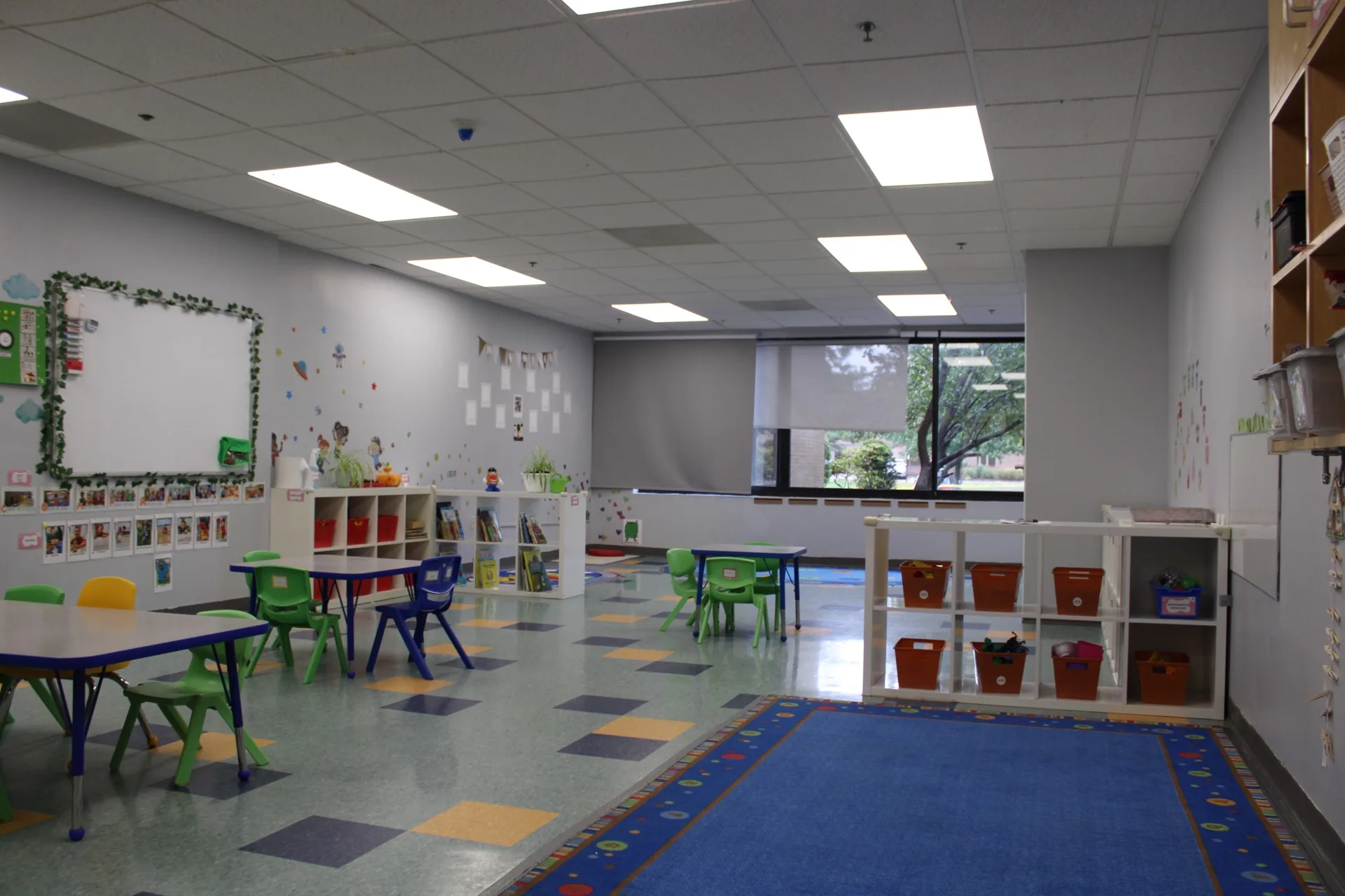 A bright Early Global Education classroom at SELA's Hingham campus, with child-height tables, cubbies, and a reading corner.